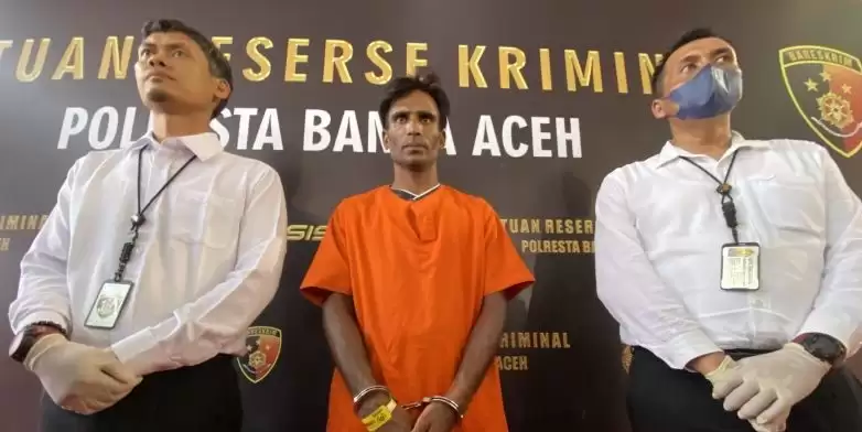 Satreskrim Polresta Banda Aceh mengawal seorang warga etnis Rohingya Muhammed Amin  yang ditetapkan sebagai tersangka dalam kasus dugaan tindak pidana penyeludupan manusia ke Indonesia di Mapolresta Banda Aceh, Aceh, Senin (18/12). (Foto: ANTARA)