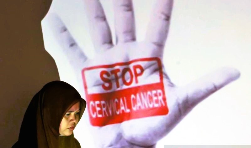 Seorang perempuan di dekat papan sosialisasi kanker serviks dan pemeriksaan pap smear. (Foto: ANTARA)