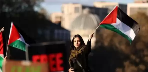 Seorang perempuan sedang membawa bendera Palestina (Foto: Ist)
                                    class=