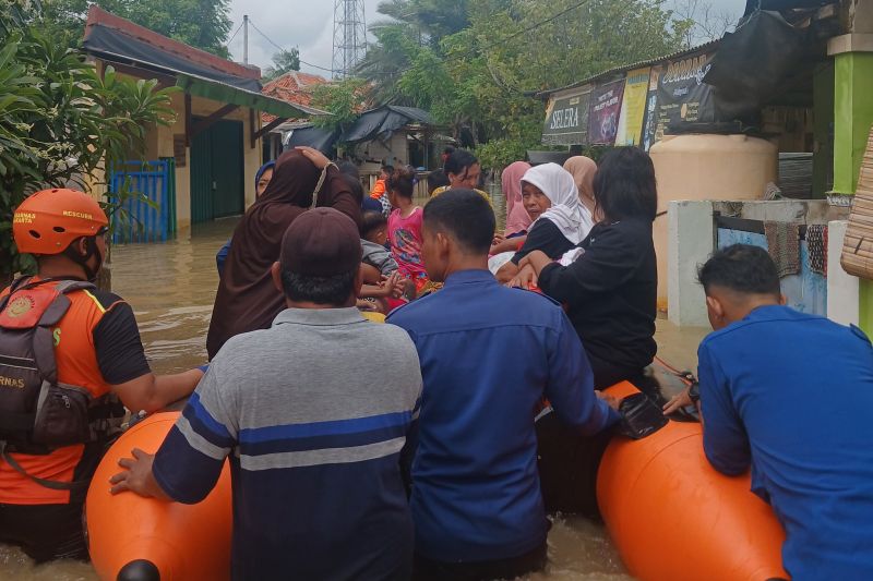 Petugas BPBD Kabupaten Tangerang saat mengevakusi warga yang terdampak banjir. (Foto: ANTARA)